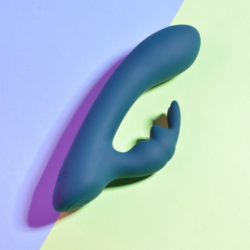 Playboy Pleasure LIL RABBIT - Deep Teal 14.6 cm USB Rechargeable Rabbit Vibrator on pastel background.