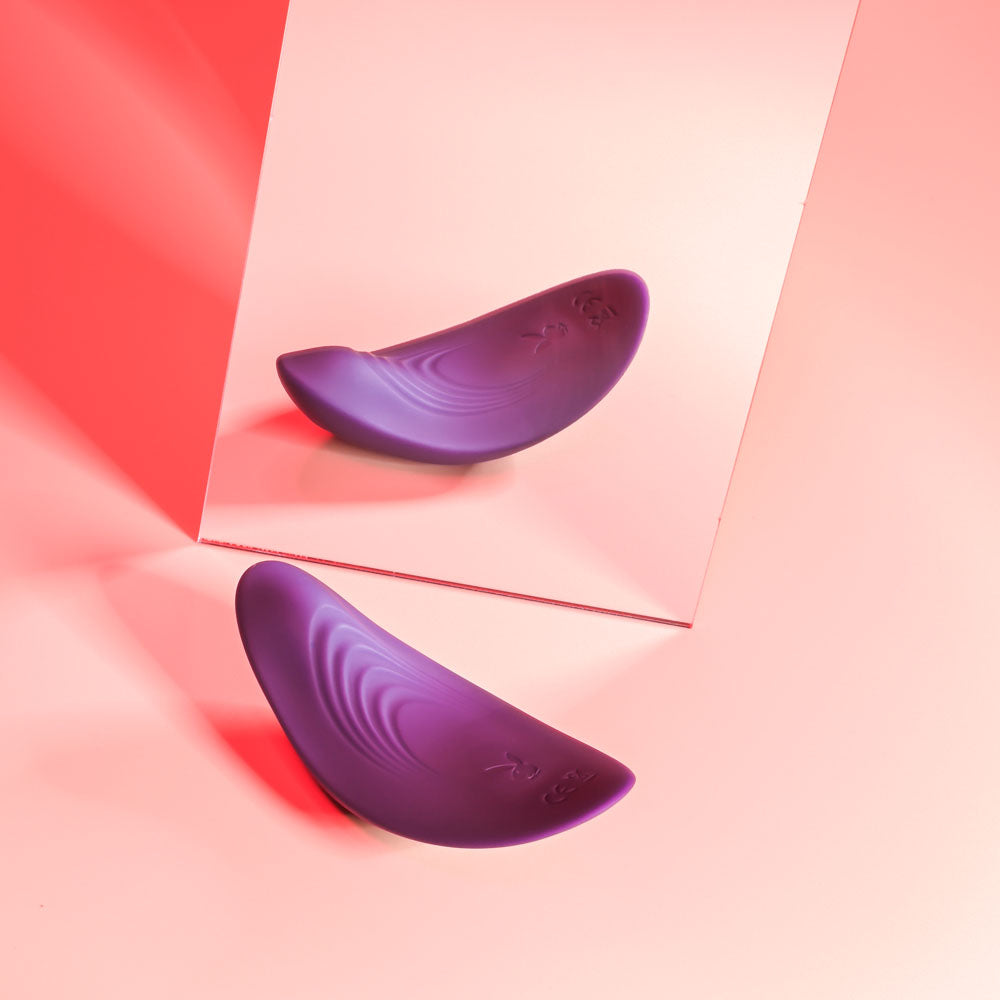 Playboy Pleasure OUR LITTLE SECRET -  USB Rechargeable Panty Vibrator with Wireless Remote Control on a pink background.