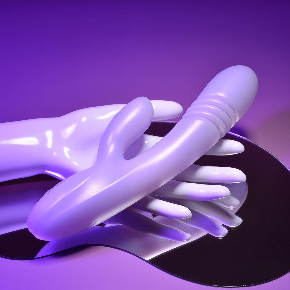 Playboy Pleasure BUMPING BUNNY - Opal 22.9 cm USB Rechargeable Thrusting & Warming Rabbit Vibrator on a reflective surface.