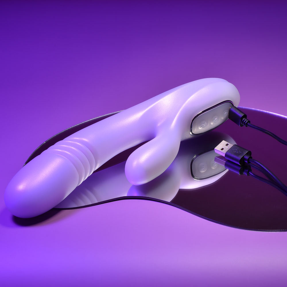 Playboy Pleasure BUMPING BUNNY - Opal 22.9 cm USB Rechargeable Thrusting & Warming Rabbit Vibrator on a reflective surface.