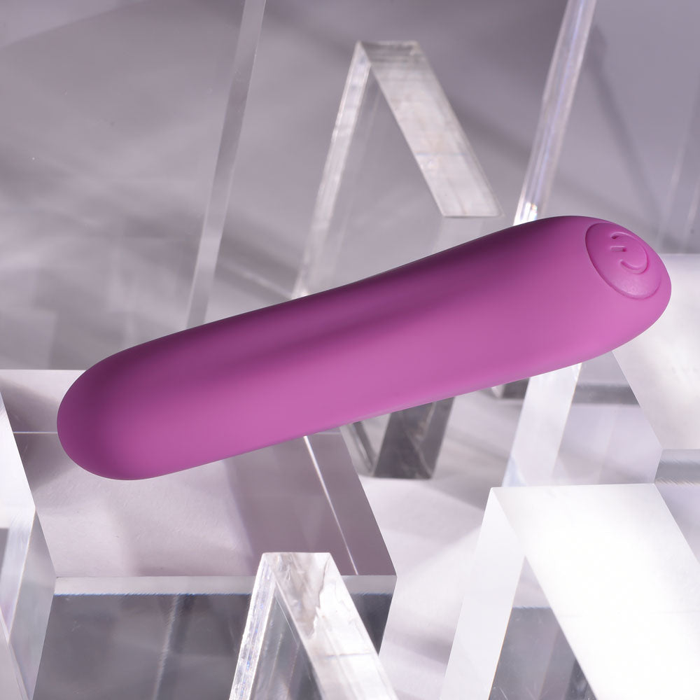 Playboy Pleasure PLAYBOY BULLET -  9 cm USB Rechargeable Bullet on a clear surface.