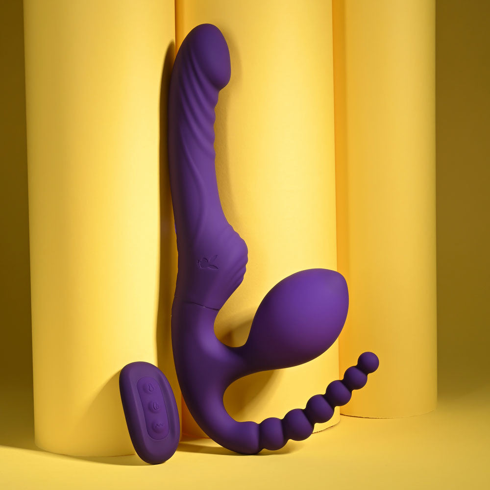Playboy Pleasure HUG IT OUT - 29 cm USB Rechargeable Strapless Strap-On in vibrant purple against yellow backdrop.