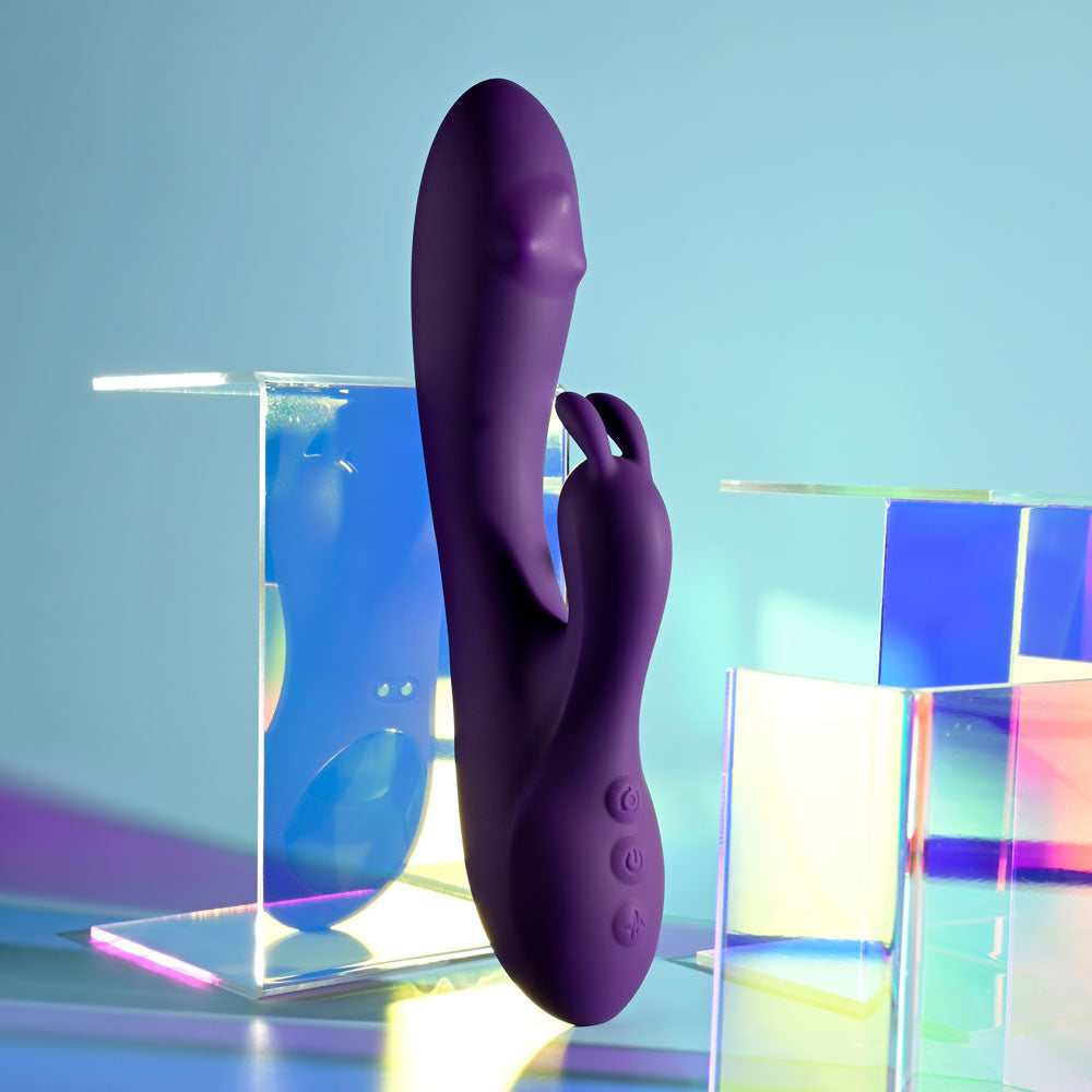 Playboy Pleasure ON REPEAT -  19.7 cm USB Rechargeable Rabbit Vibrator in purple against colorful background.