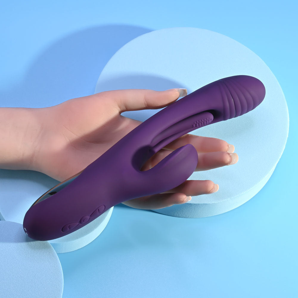 USB rechargeable rabbit vibrator in purple color, featuring a unique design and texture, held in a hand on a blue background.
