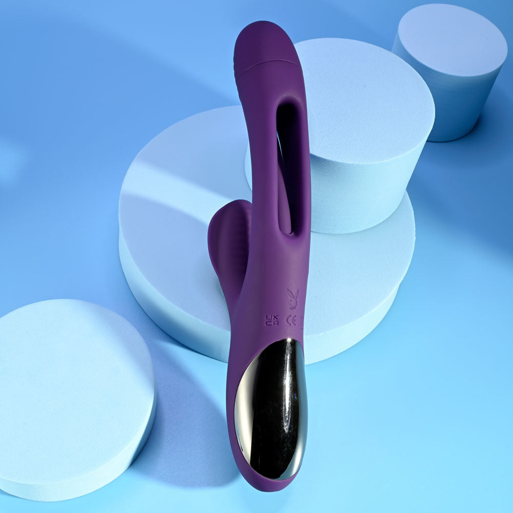 USB rechargeable rabbit vibrator in vibrant purple color on a blue background with circular geometric shapes.