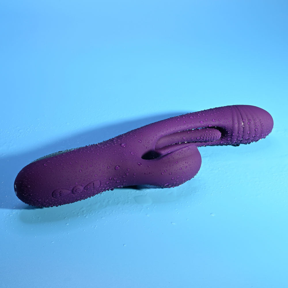 Playboy Pleasure THE THRILL - 24.4 cm USB Rechargeable Rabbit Vibrator in purple with water droplets.