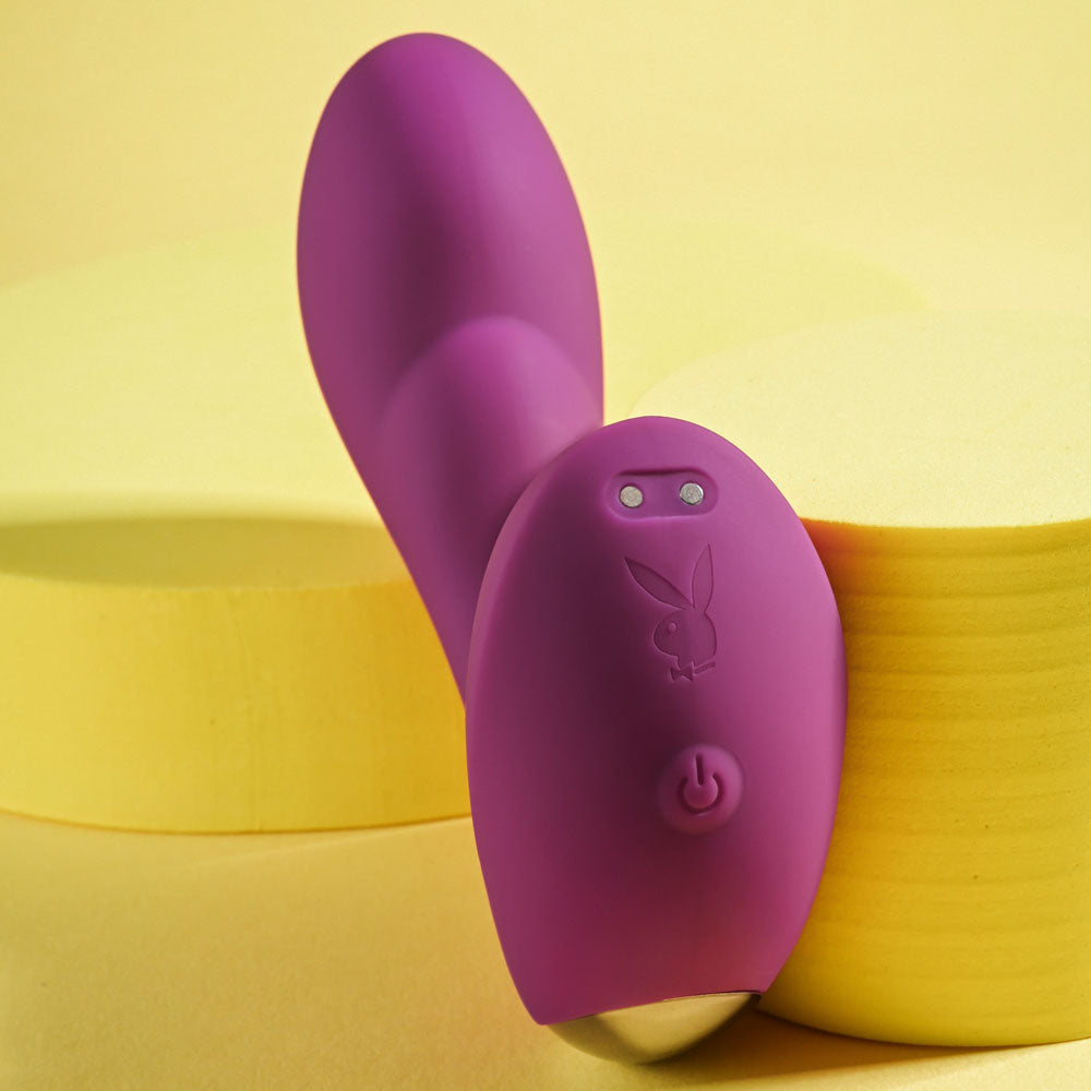 Playboy Pleasure ARCH - 14.1 cm USB Rechargeable G-Spot Vibrator in vibrant purple against a yellow background.
