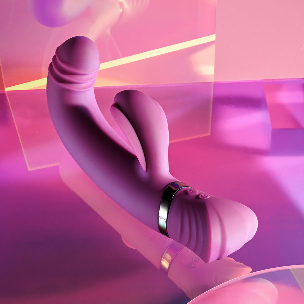 Playboy Pleasure TAP THAT - 16.5 cm USB Rechargebale Rabbit Vibrator in vibrant pink against a colorful background.