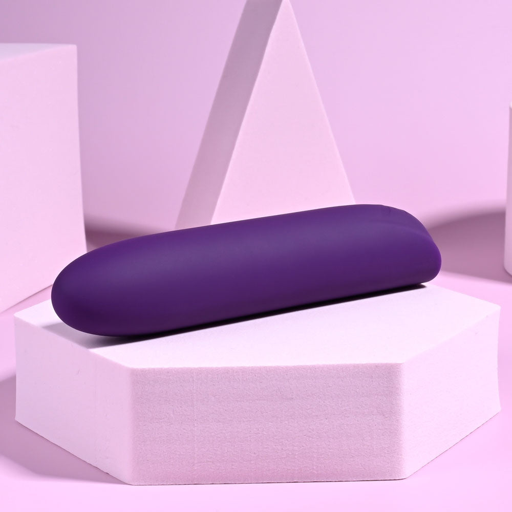 Playboy Pleasure ONE & ONLY - 12 cm USB Rechargeable Bullet on a pink geometric surface.