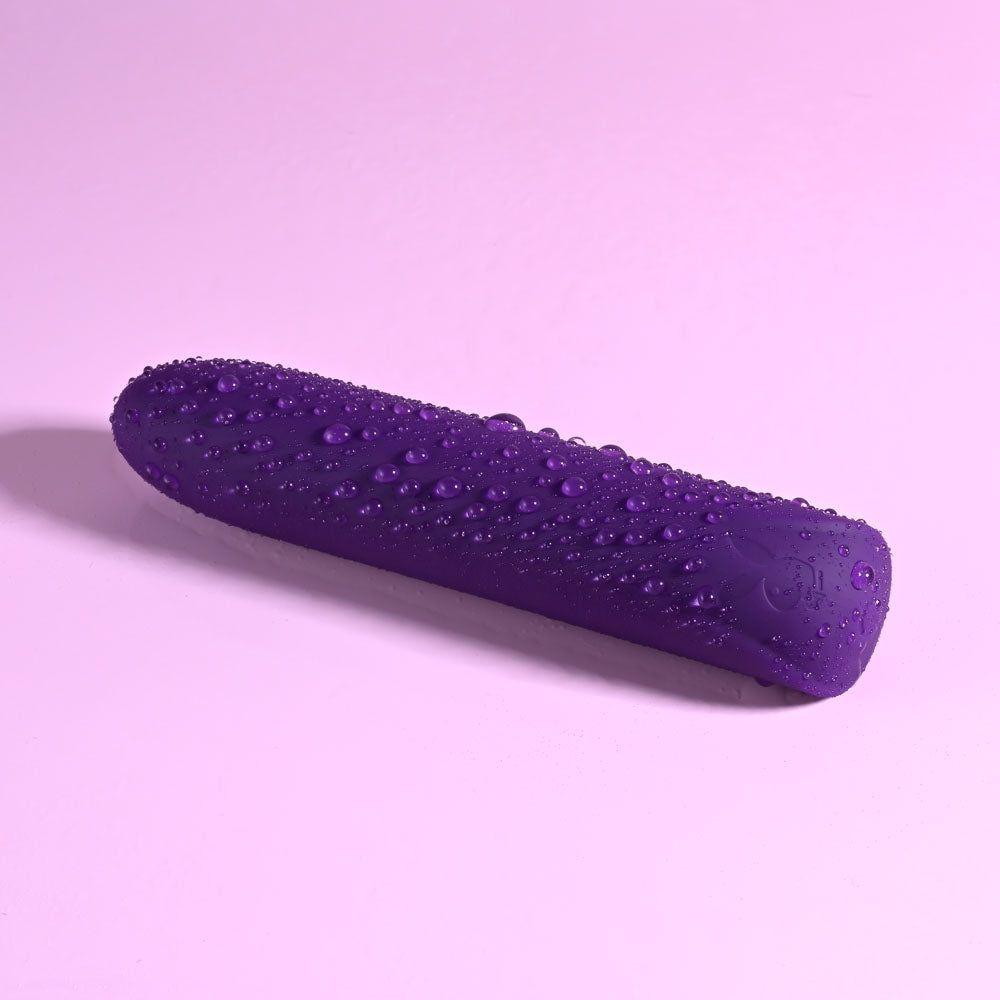 Playboy Pleasure ONE & ONLY -  12 cm USB Rechargeable Bullet displayed on a purple background, showcasing its sleek design.