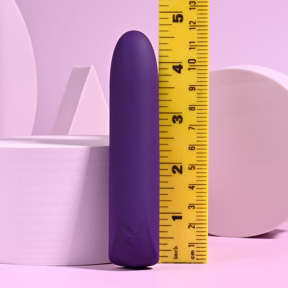 Playboy Pleasure ONE & ONLY - 12 cm USB Rechargeable Bullet next to a measuring tape on a pastel pink background.