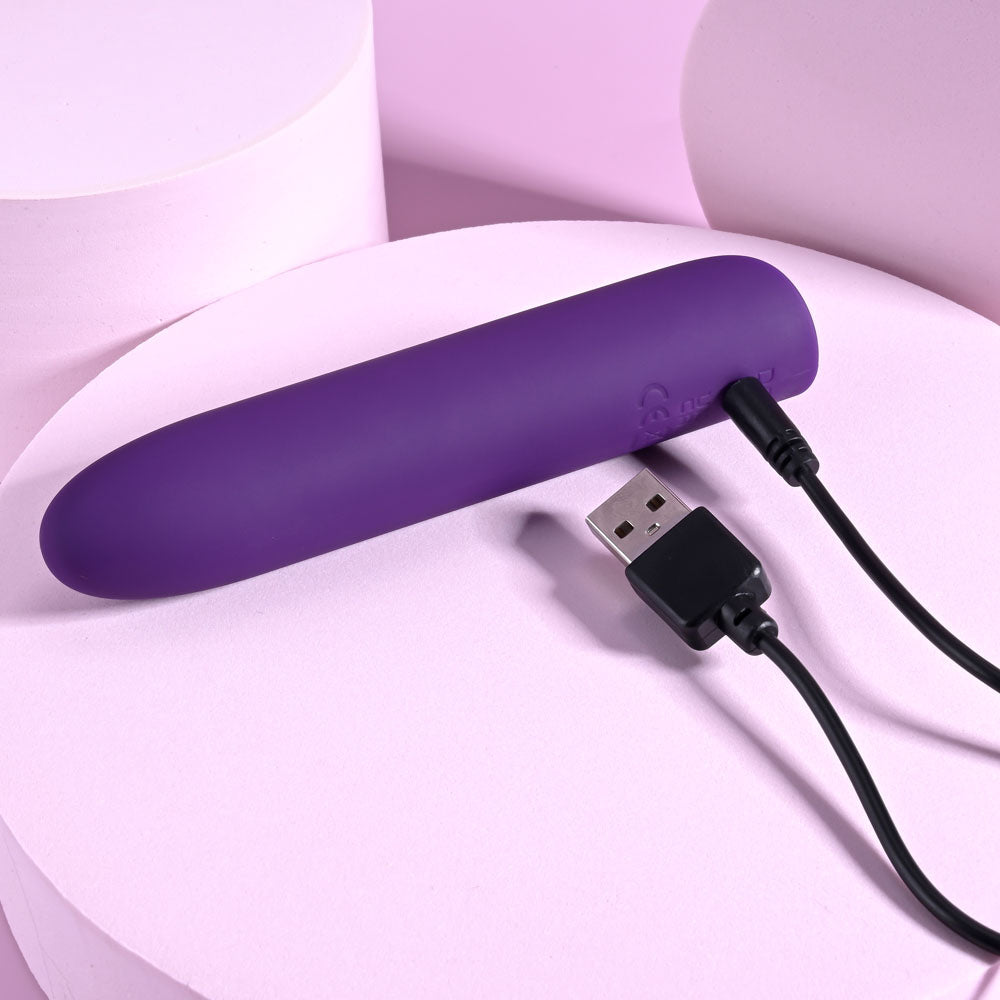 Playboy Pleasure ONE & ONLY -  12 cm USB Rechargeable Bullet on a pink background with charging cable.