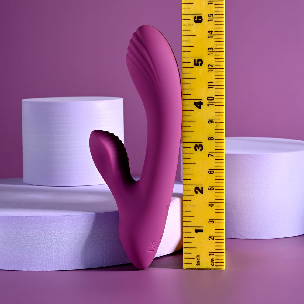 Playboy Pleasure BITTY BUNNY - 14.7 cm USB Rechargeable Rabbit Vibrator next to measuring tape for size reference.