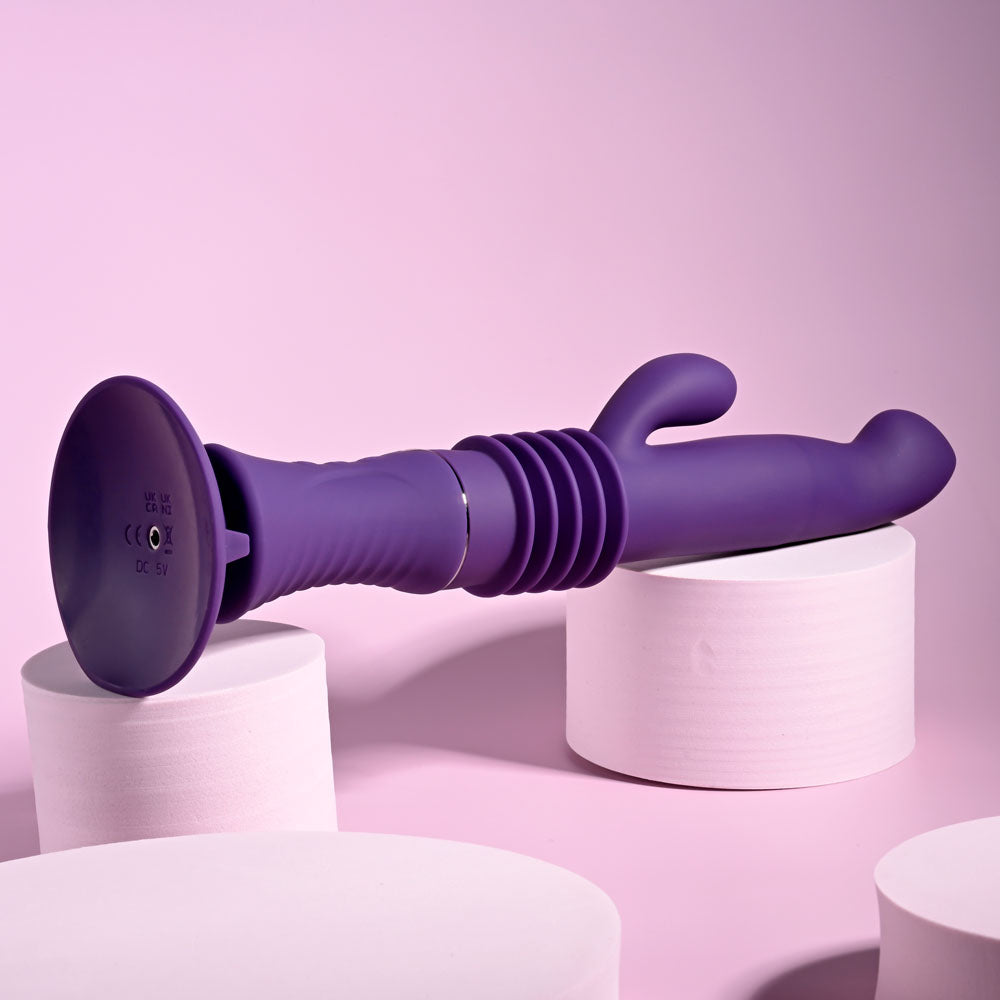 Playboy Pleasure HOPPY ENDING - 29.2 cm USB Rechargeable Thrusting Rabbit Vibrator on pastel background.