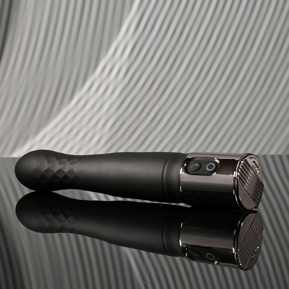 Playboy Pleasure PLEASURE ZONE - 21.4 cm Rechargeable Vibrator with USB Charging Dock on a reflective surface.
