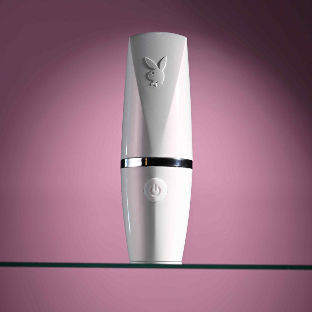 Playboy Pleasure GETAWAY - White/ 14.2 cm USB Rechargeable Tapping Stimulator on a glass shelf.