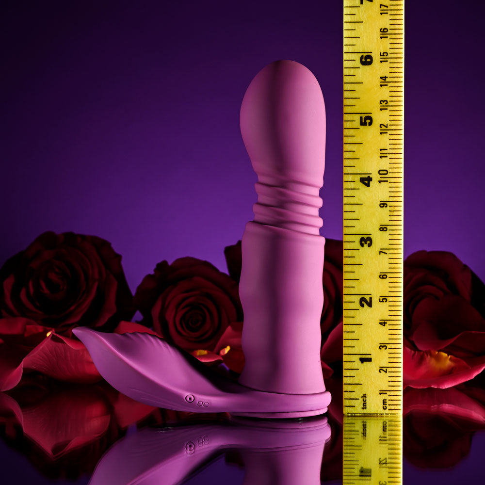Playboy Pleasure MATCH PLAY - USB Rechargeable with C-Ring Attachment next to a ruler and roses in a vibrant setting.