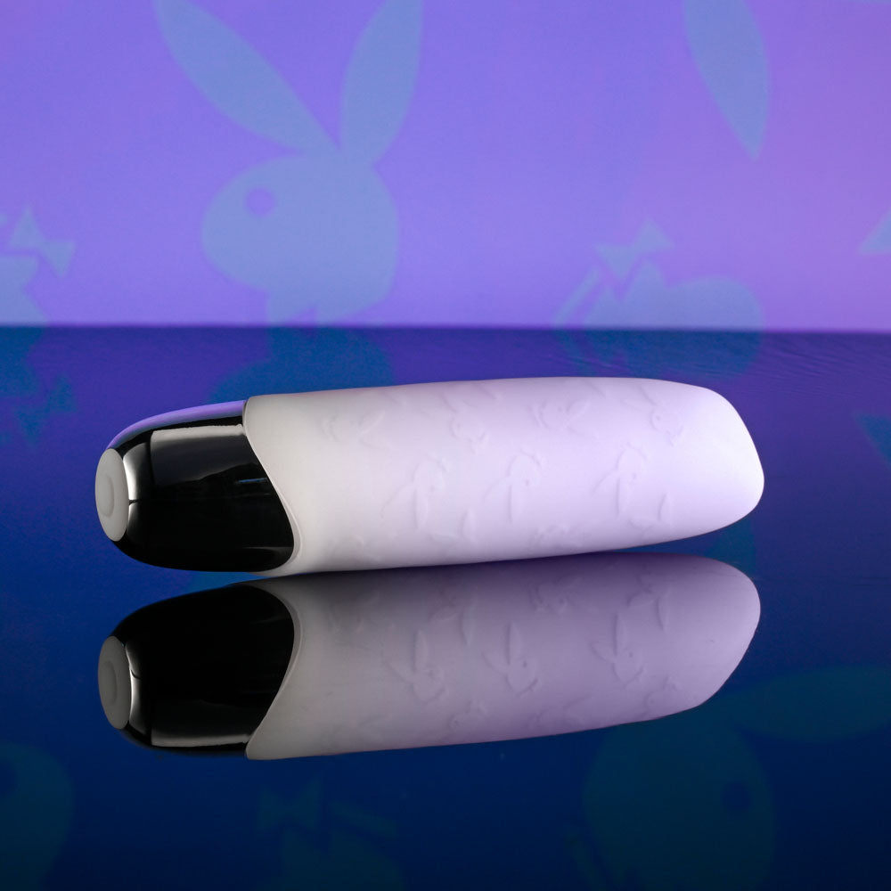 Playboy Pleasure BUNNY BUNCH - Pearl 11.3 cm USB Rechargeable Bullet on a reflective surface with a colorful background.