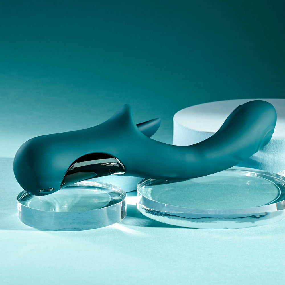 Playboy Pleasure HARMONY - 22.9 cm USB Rechargeable Vibrator with Clitoral Flicker resting on glass discs.