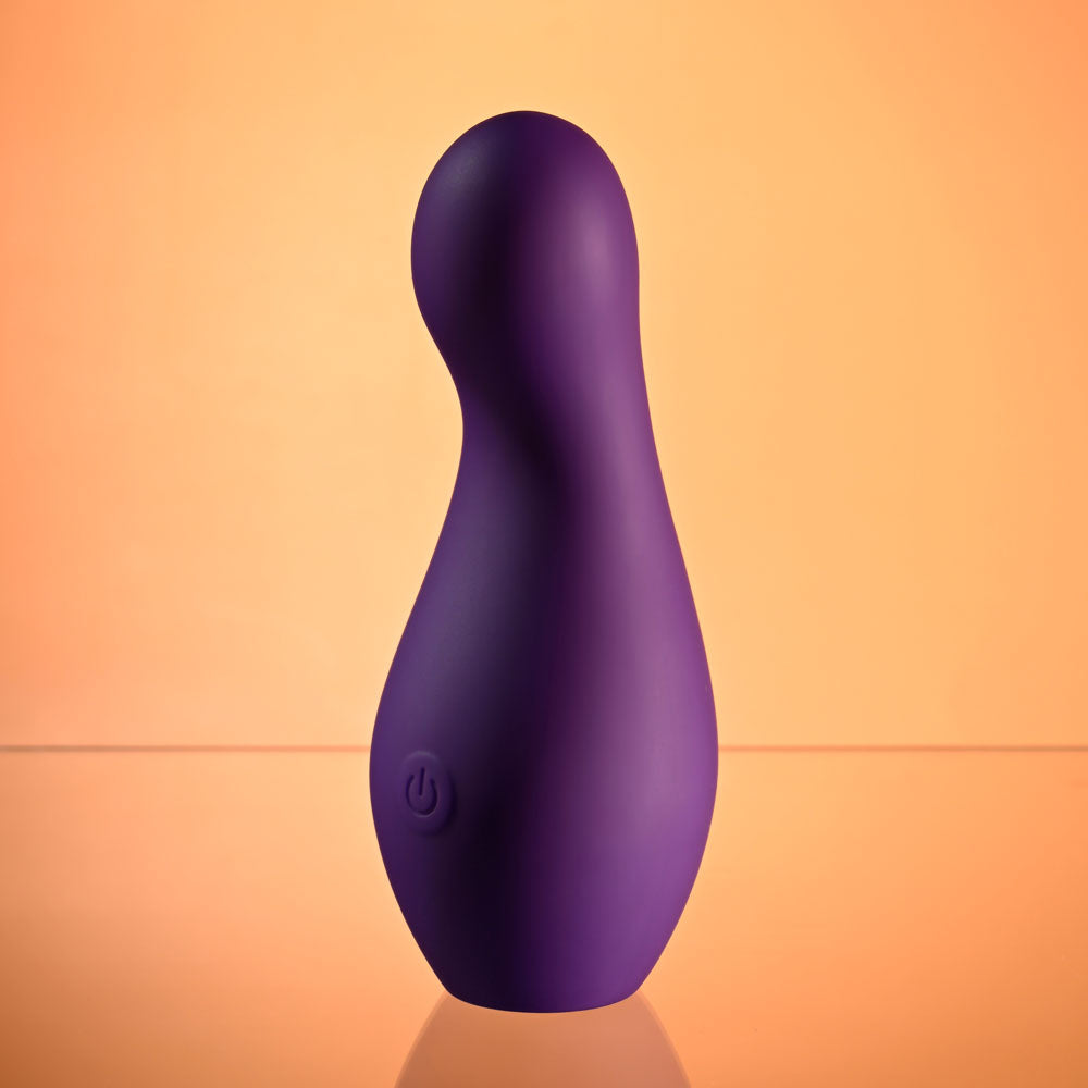 Playboy Pleasure THE JET SET - VIBRATOR - 10.2 cm Vibrator with Self Charging Case in purple silicone on a reflective surface.