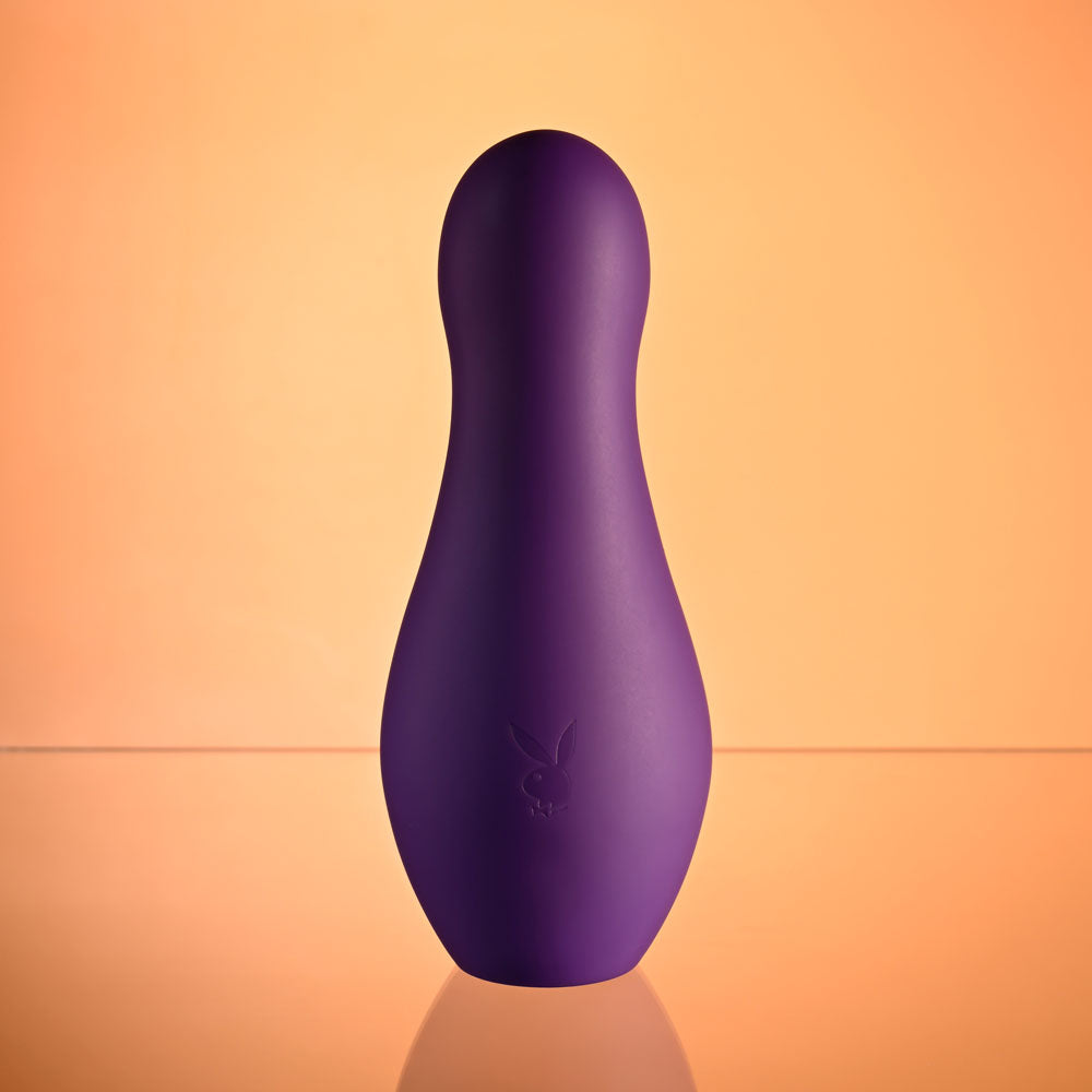 Playboy Pleasure THE JET SET - VIBRATOR - 10.2 cm Vibrator with Self Charging Case in purple on a vibrant background.