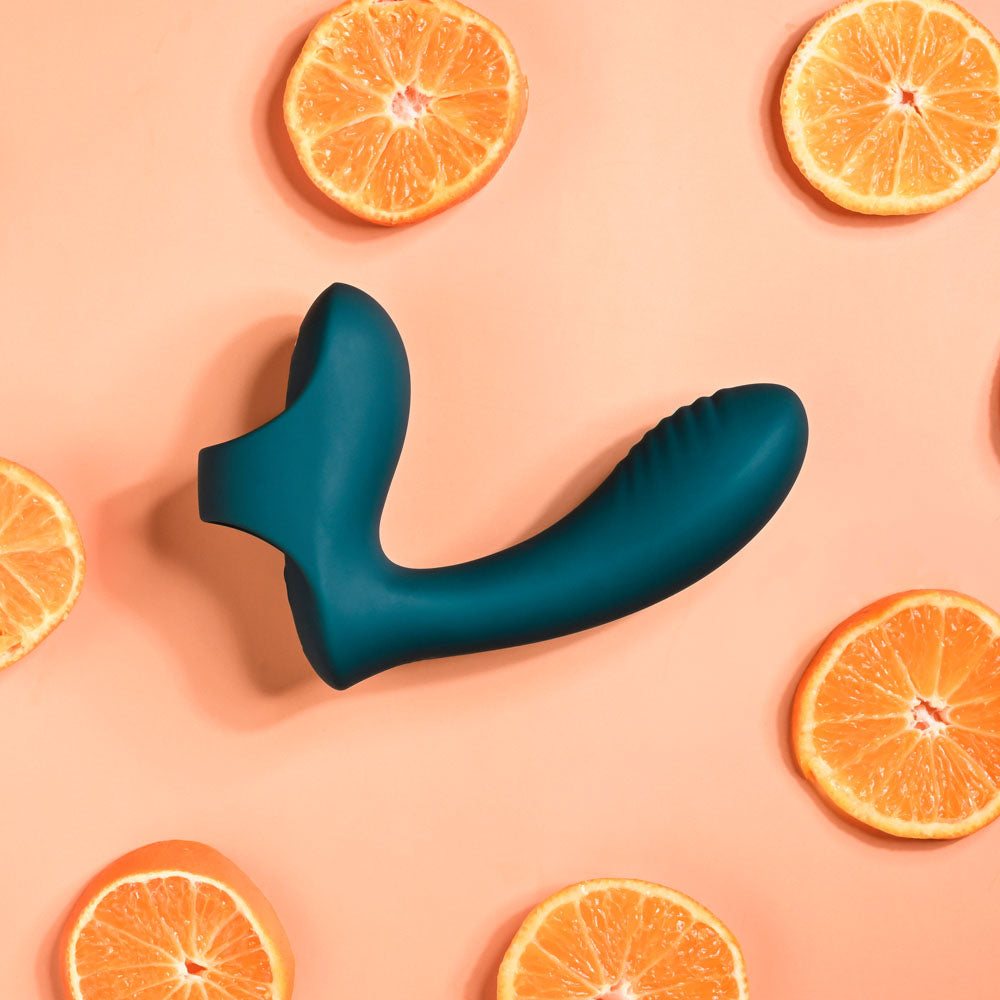 Playboy Pleasure WRAPPED AROUND YOUR FINGER -  USB Rechargeable Finger Stimulator surrounded by orange slices.