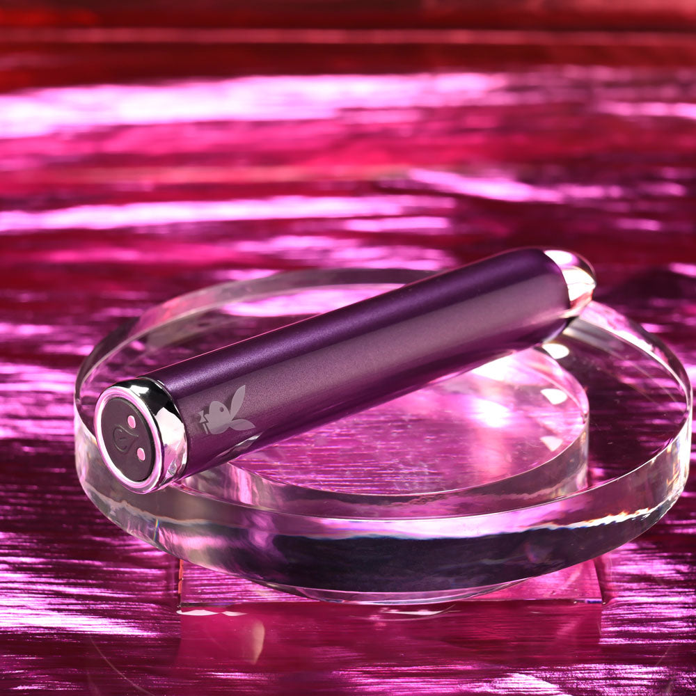 Playboy Pleasure AMETHYST - 12.4 cm USB Rechargeable Glass Tipped Mini Vibrator on a crystal base with a vibrant background.