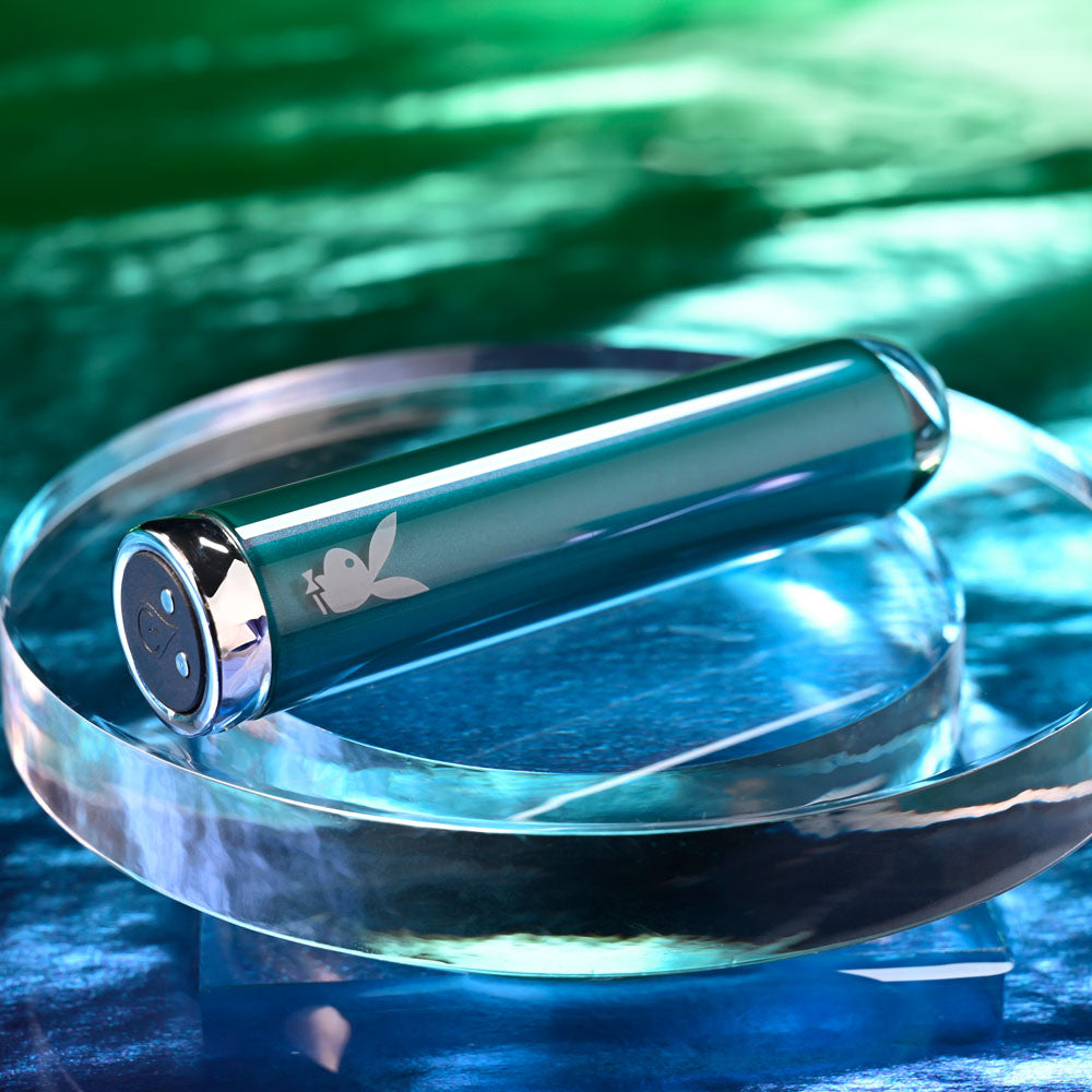 Playboy Pleasure EMERALD -  9.1 cm USB Rechargeable Glass Tipped Bullet displayed on a shiny glass surface.