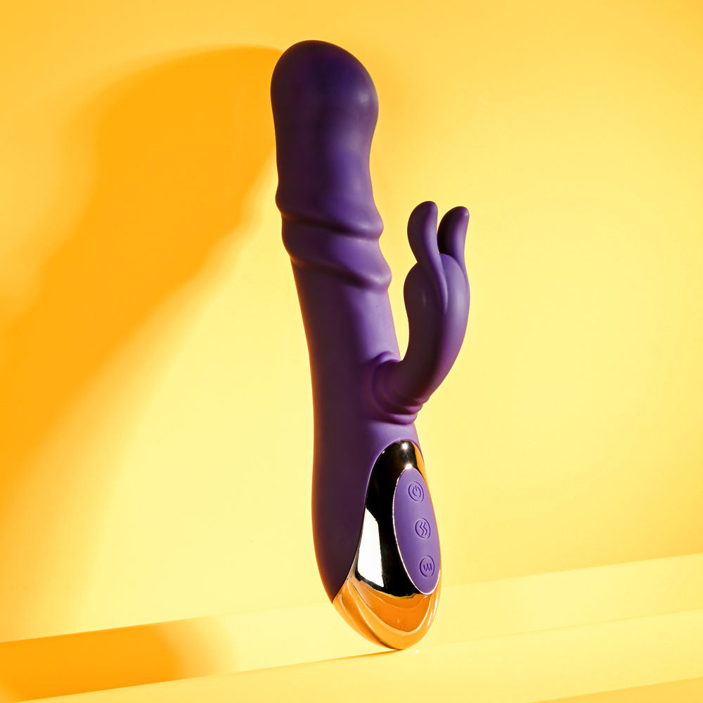 Playboy Pleasure BUNNY PUNCH - 24.4 cm USB Rechargeable Twirling Rabbit Vibrator on a yellow background.