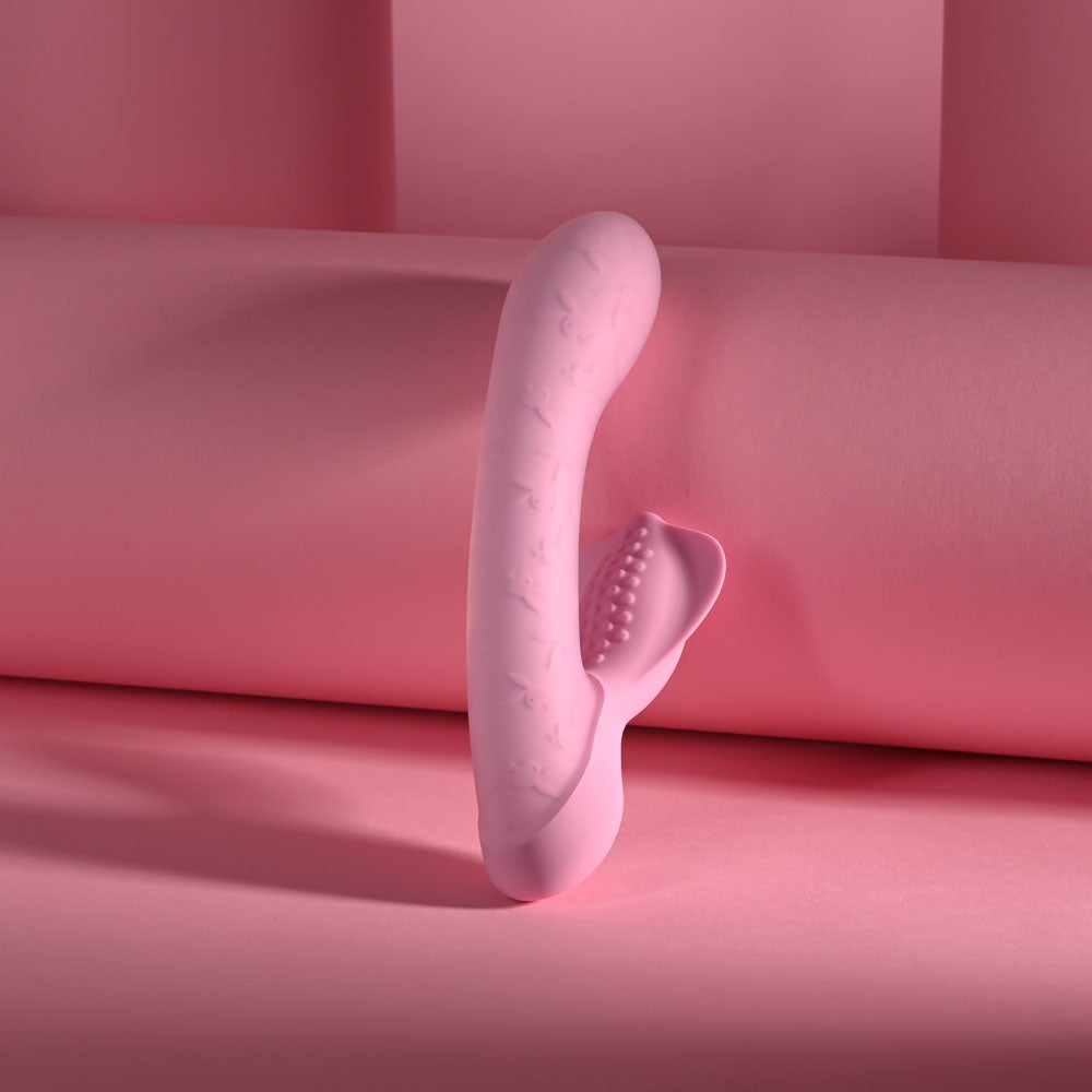 Playboy Pleasure Rabbit Party USB rechargeable rabbit vibrator in soft pink color against a pink background.