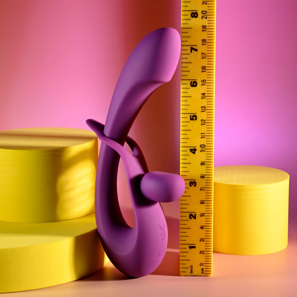 Playboy Pleasure CHA CHA SLIDE -  20 cm USB Rechargeable Rabbit Vibrator displayed next to a ruler on colorful geometric shapes.