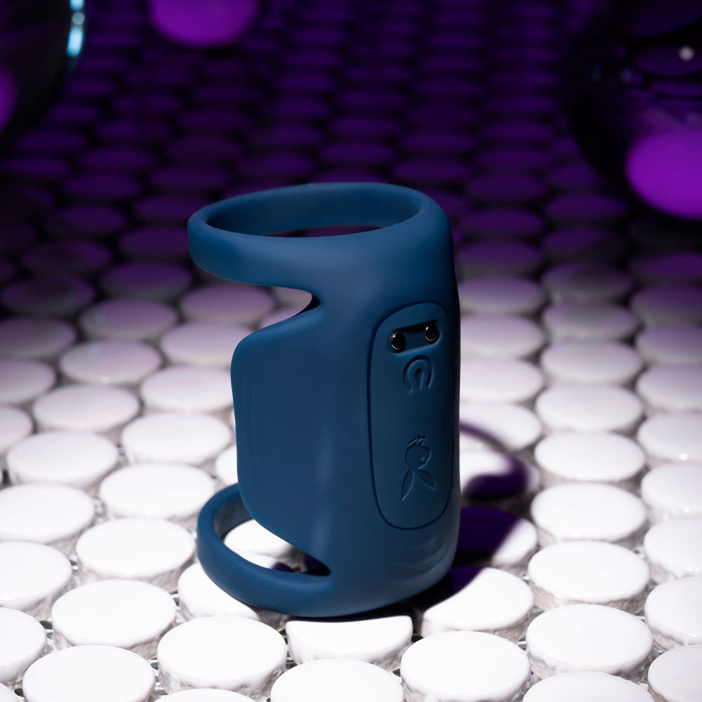 Playboy Pleasure Jet Pack dark USB rechargeable vibrating penis harness on a tiled surface.