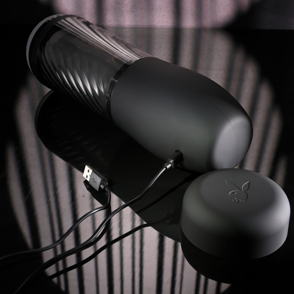 Playboy Pleasure WHIRLWIND - USB Rechargeable Thrusting and Spinning Auto Stroker on a reflective surface.