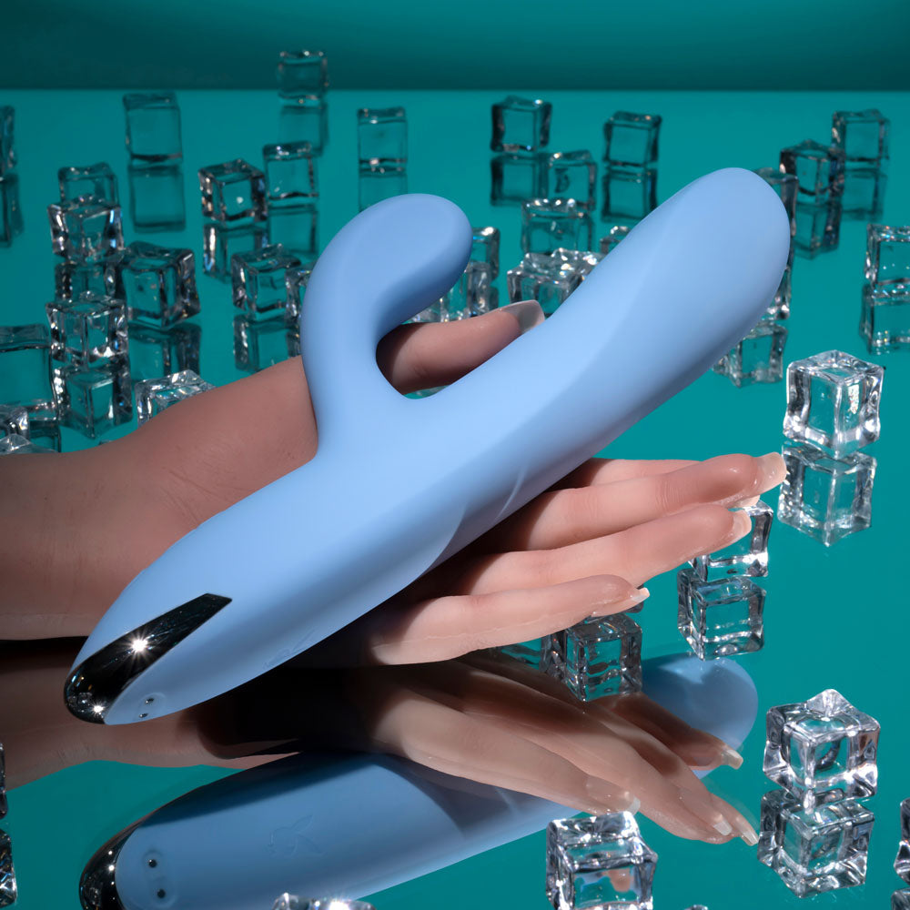 USB rechargeable rabbit vibrator in blue, showcased on a reflective surface with ice cubes, highlighting its design.