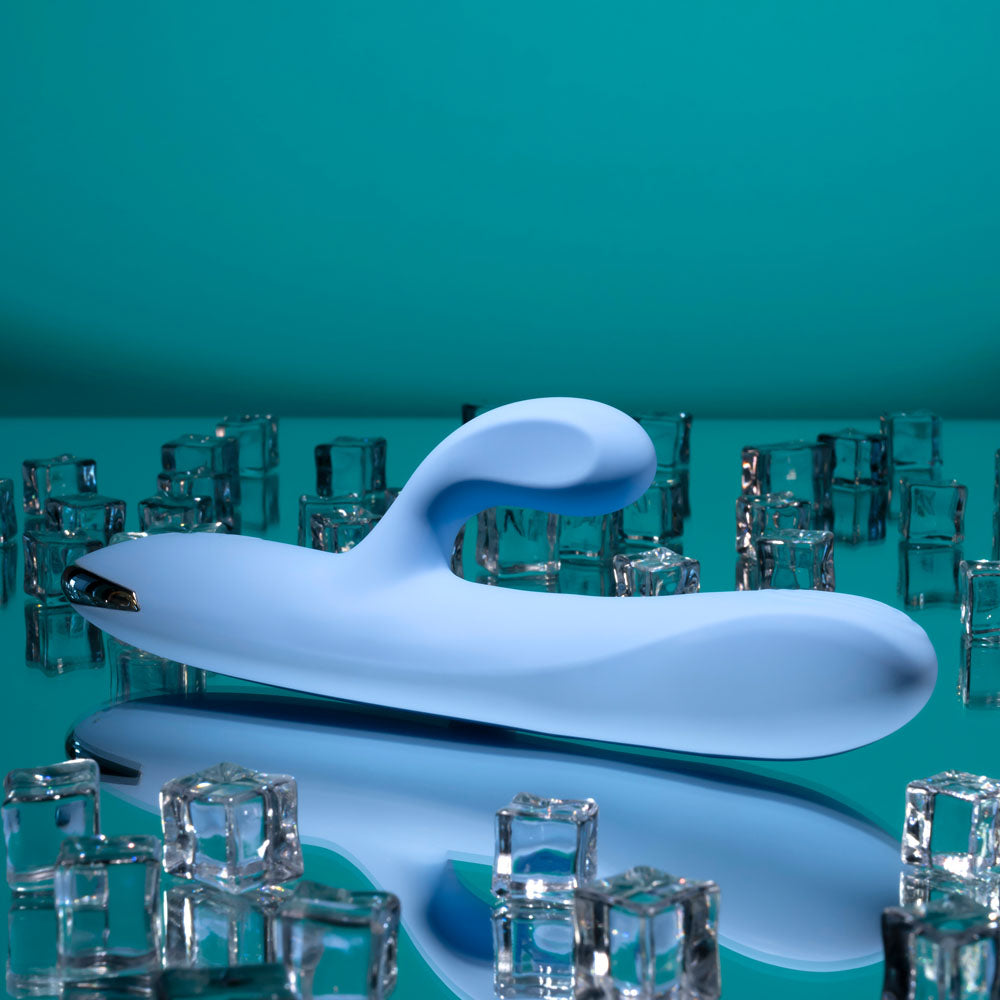 USB rechargeable rabbit vibrator surrounded by ice cubes on a reflective surface.