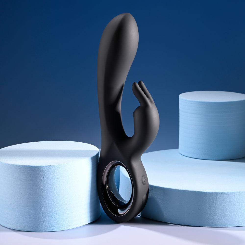 USB rechargeable rabbit vibrator positioned between two soft blue blocks on a stylish backdrop.