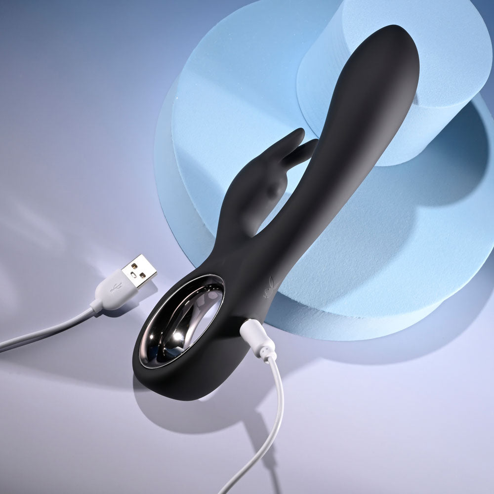 Playboy Pleasure LATE NIGHT BUNNY - 20 cm USB Rechargeable Rabbit Vibrator charging on a colorful background.
