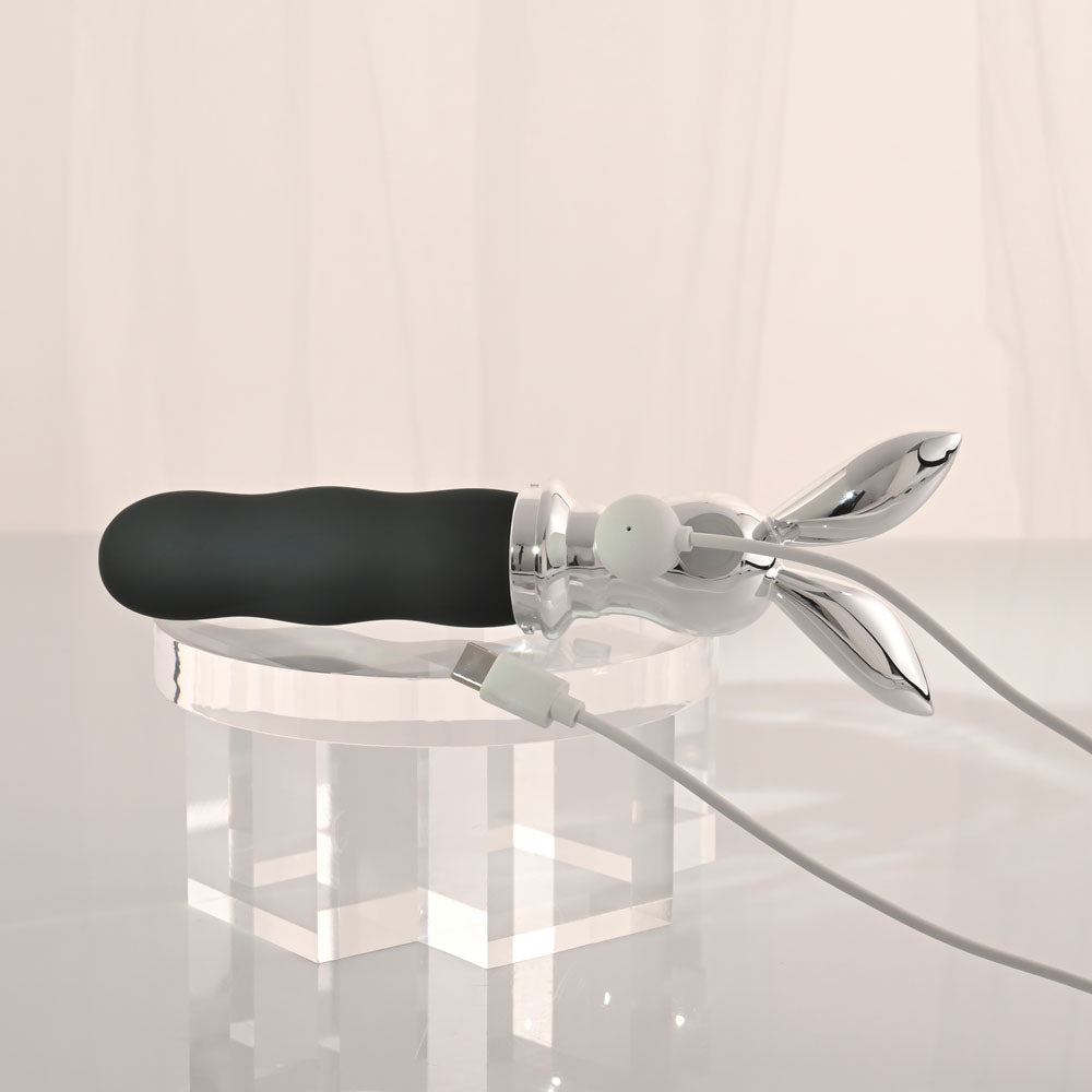 Playboy Pleasure BUNNY ON THE GO - /Chrome 18.6 cm USB-C Rechargeable Vibrator charging on a clear display.