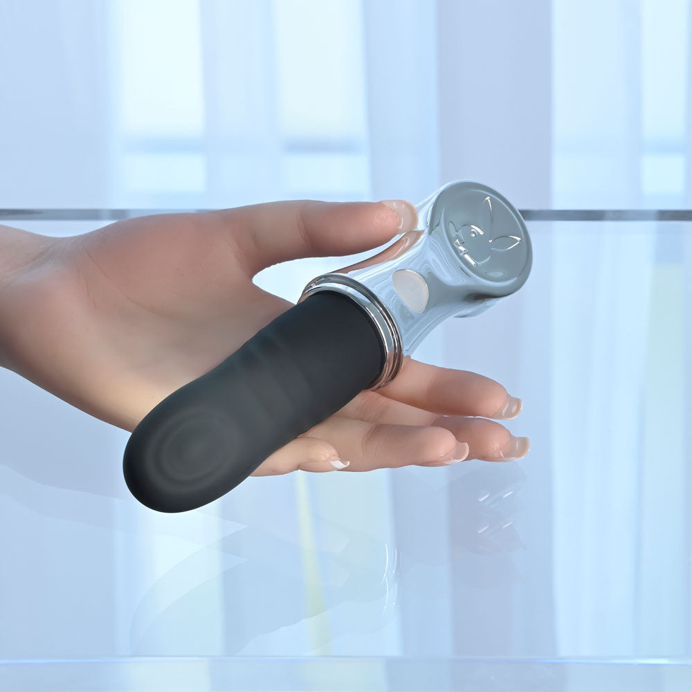 Playboy Pleasure BON VOYAGE - /Chrome 18.7 cm USB-C Rechargeable Tapping Vibrator held in a hand.
