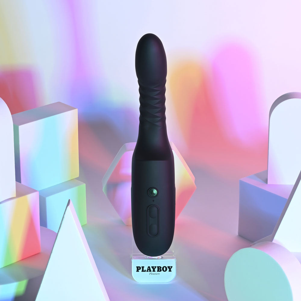 Playboy Pleasure OVERDRIVE - 28.2 cm USB Rechargeable Thrusting Vibrator displayed against colorful geometric shapes.