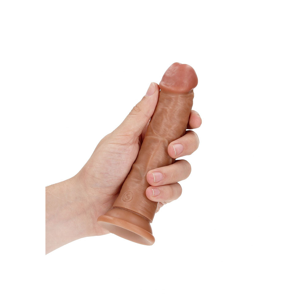 REALROCK realistic curved dildo with suction cup held in hand, showcasing its lifelike design and texture.