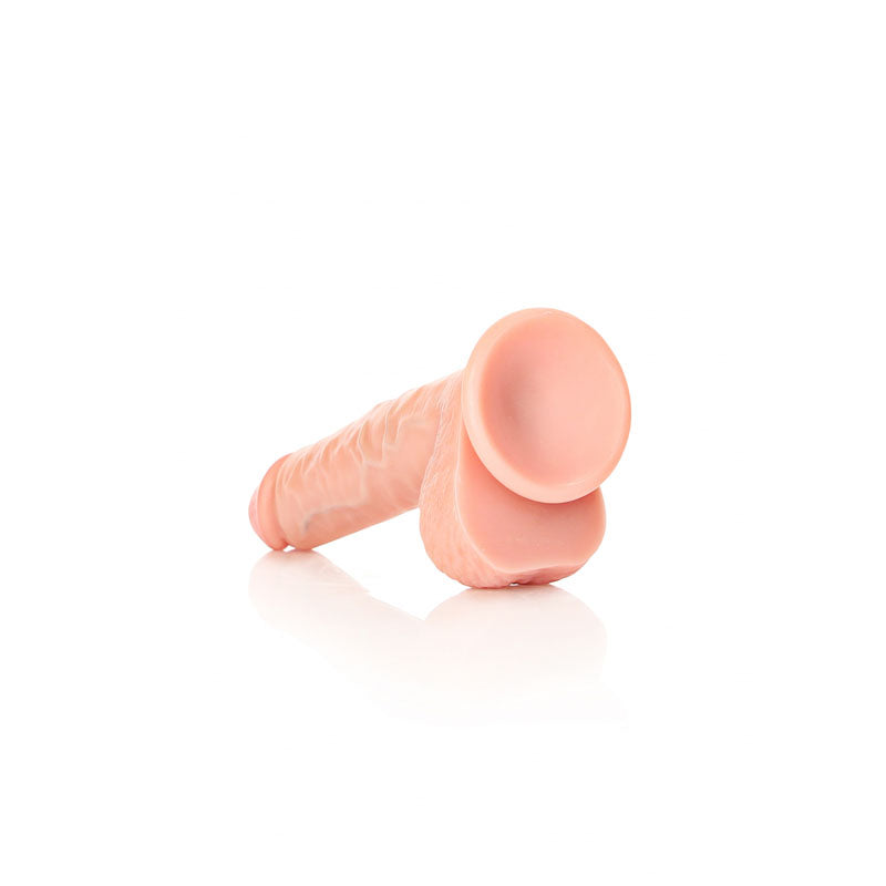 REALROCK Straight Realistic Dildo with Balls - 18 cm - 18 cm (7'') Dong on a reflective surface.