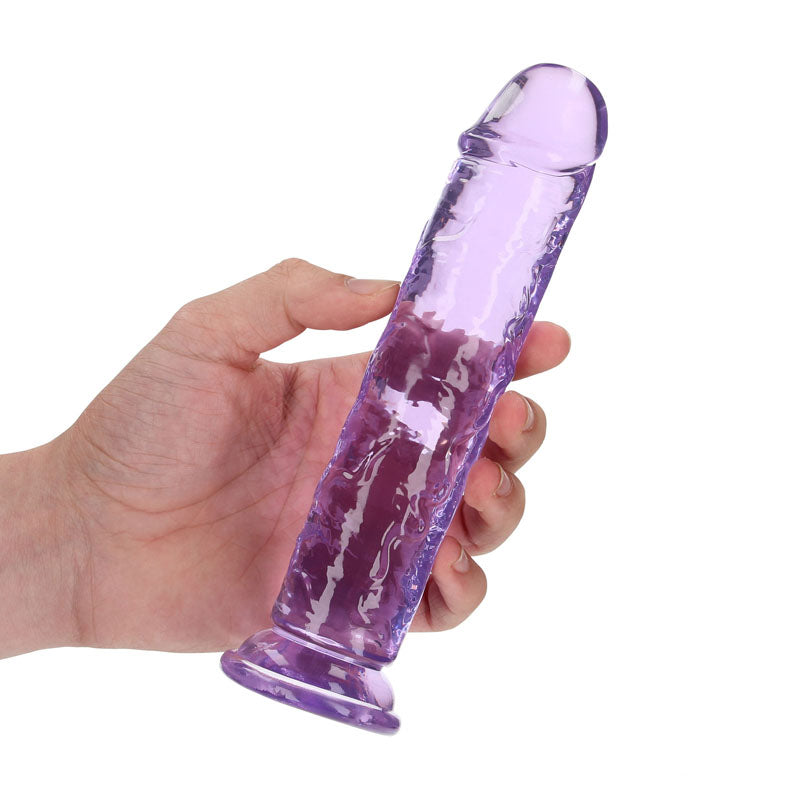 Hand holding a REALROCK 18 cm straight dildo in clear purple, designed for vaginal and anal pleasure.