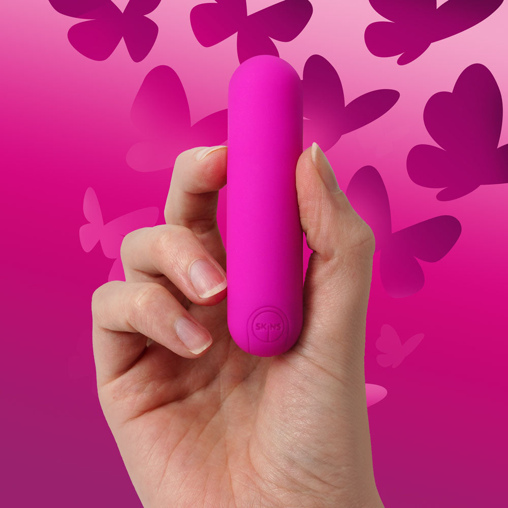 Skins Super Excite Rechargeable  Bullet -  USB Rechargeable Bullet held in hand against a pink butterfly background.