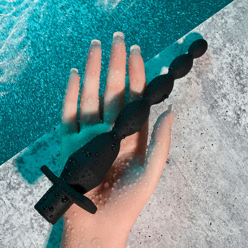 Selopa VIBRATING BUTT BEADS -  22 cm USB Rechargeable Vibrating Anal Beads on a hand with water droplets