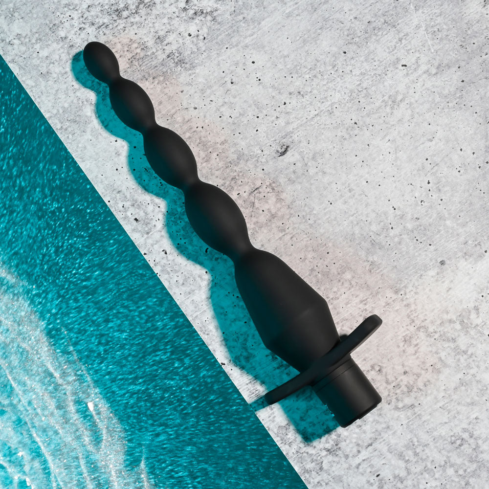 Selopa VIBRATING BUTT BEADS - 22 cm USB Rechargeable Vibrating Anal Beads on a textured surface.