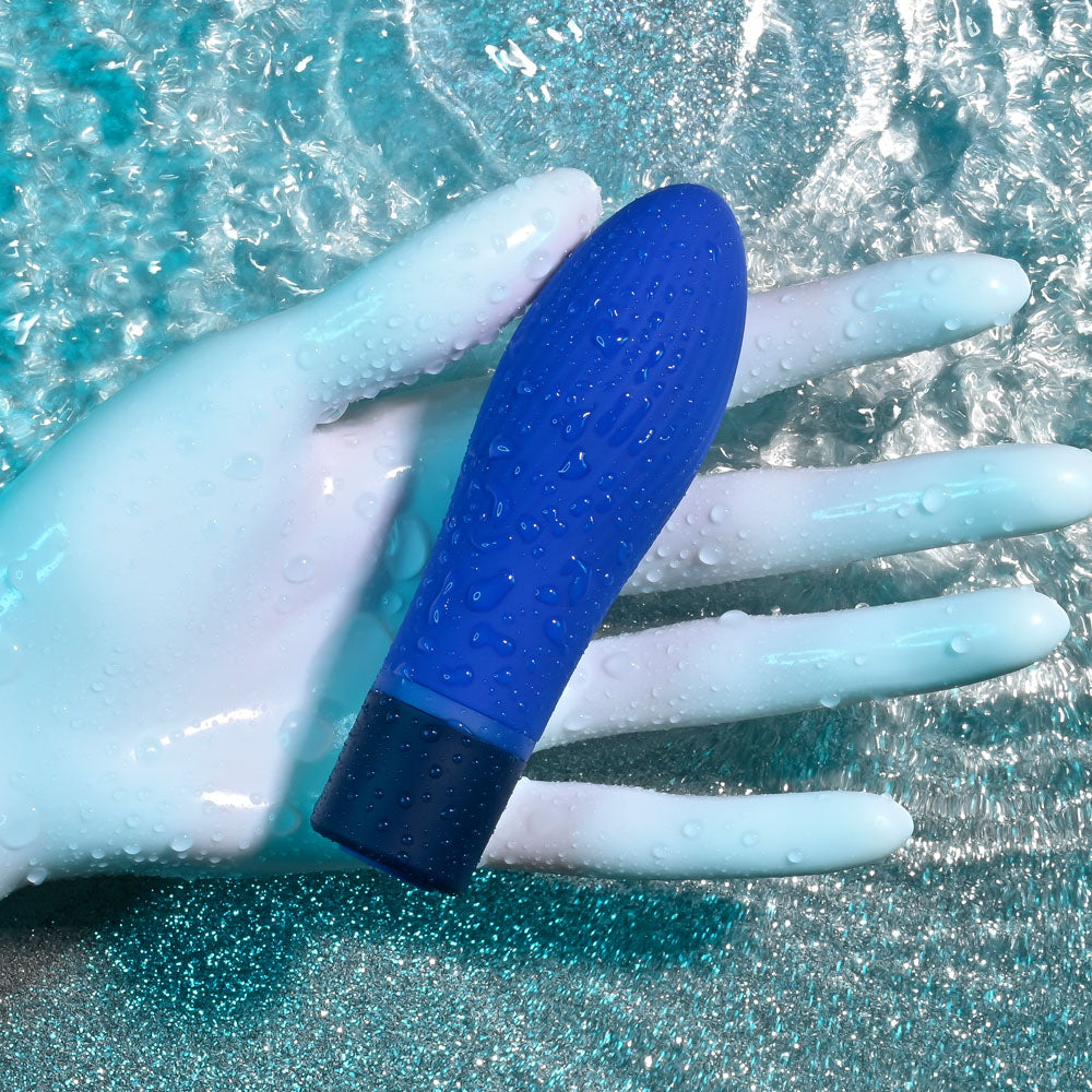Selopa COBALT CUTIE - blue vibrator resting on a gloved hand, showcasing its sleek design and waterproof features.