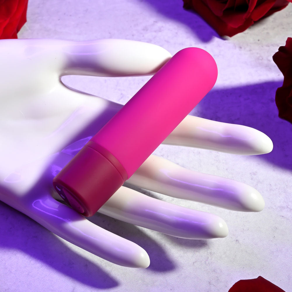 Selopa TINY TEMPTATION - 9.2 cm USB Rechargeable Bullet on a hand with rose petals in the background.