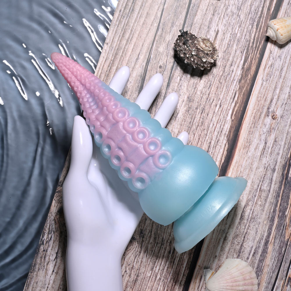 Selopa STUCK ON YOU - Blue/Pink 19 cm USB Rechargeable Vibrating Tentacle Fantasy Dildo in hand on wooden surface.