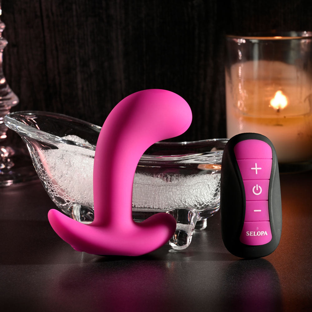 Selopa HOOKING UP - 9.5 cm USB Rechargeable Vibrator with Wireless Remote next to a decorative bowl and candle.